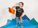 little-kid-playing-with-a-paper-boat-while-wearing-a-round-neck-tshirt-template-a16142.webp
